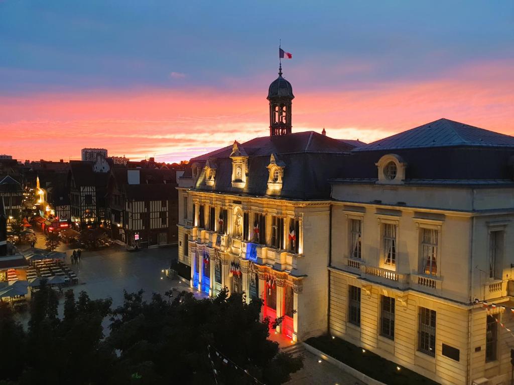 un edificio con una torre de reloj en la parte superior al atardecer en Le cœur de Troyes - Appartement & Studio en Troyes