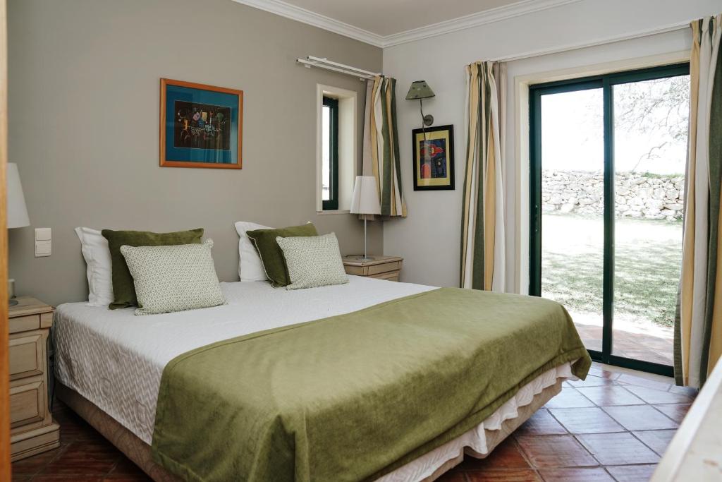 a bedroom with a large bed and a large window at Vila Limão in Boliqueime