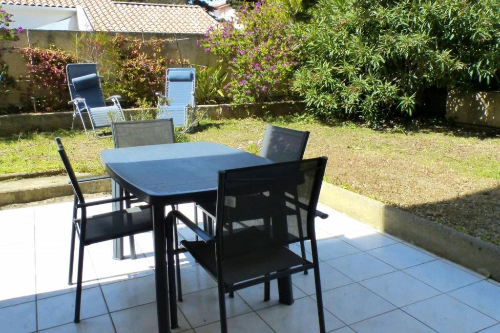 einen blauen Tisch und Stühle auf einer Terrasse in der Unterkunft Nice 33 m apartment with garden and terrace in Six-Fours-les-Plages