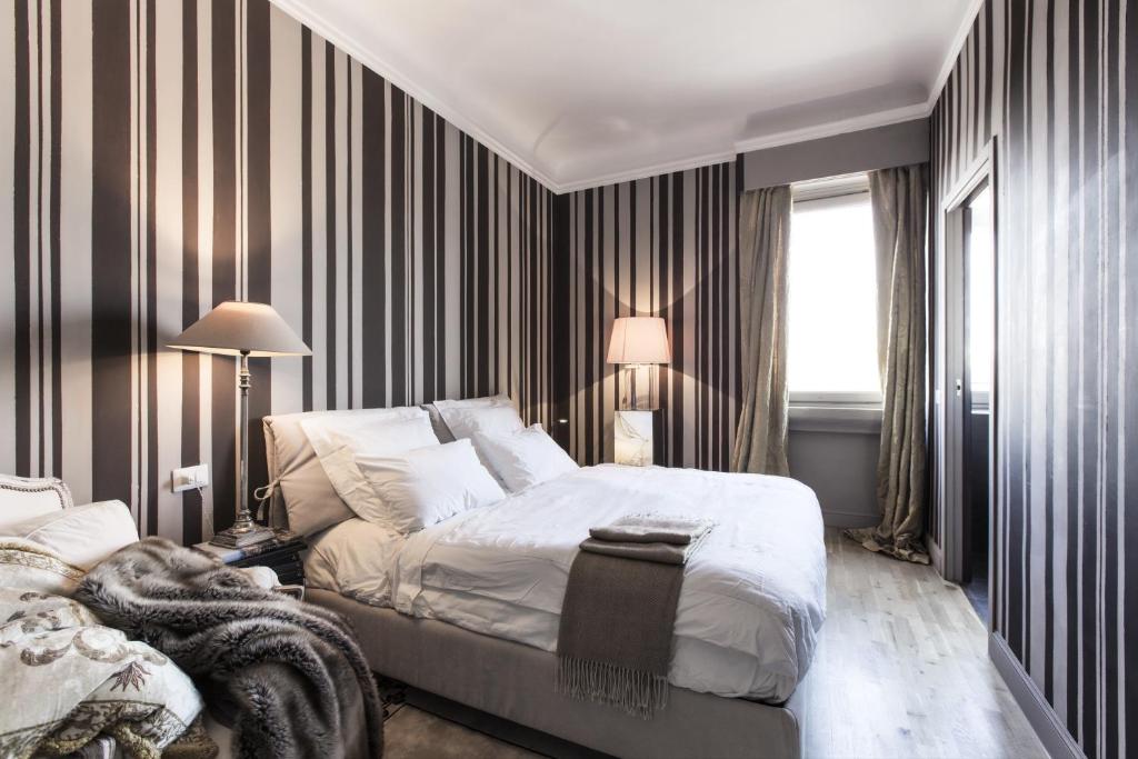 Un dormitorio con una gran cama blanca y una ventana en Pattini Guest House, en Milán