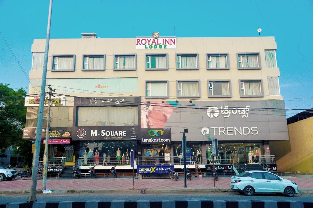 Hotel Royal Inn في Mudhol: مبنى متوقف امامه سيارة