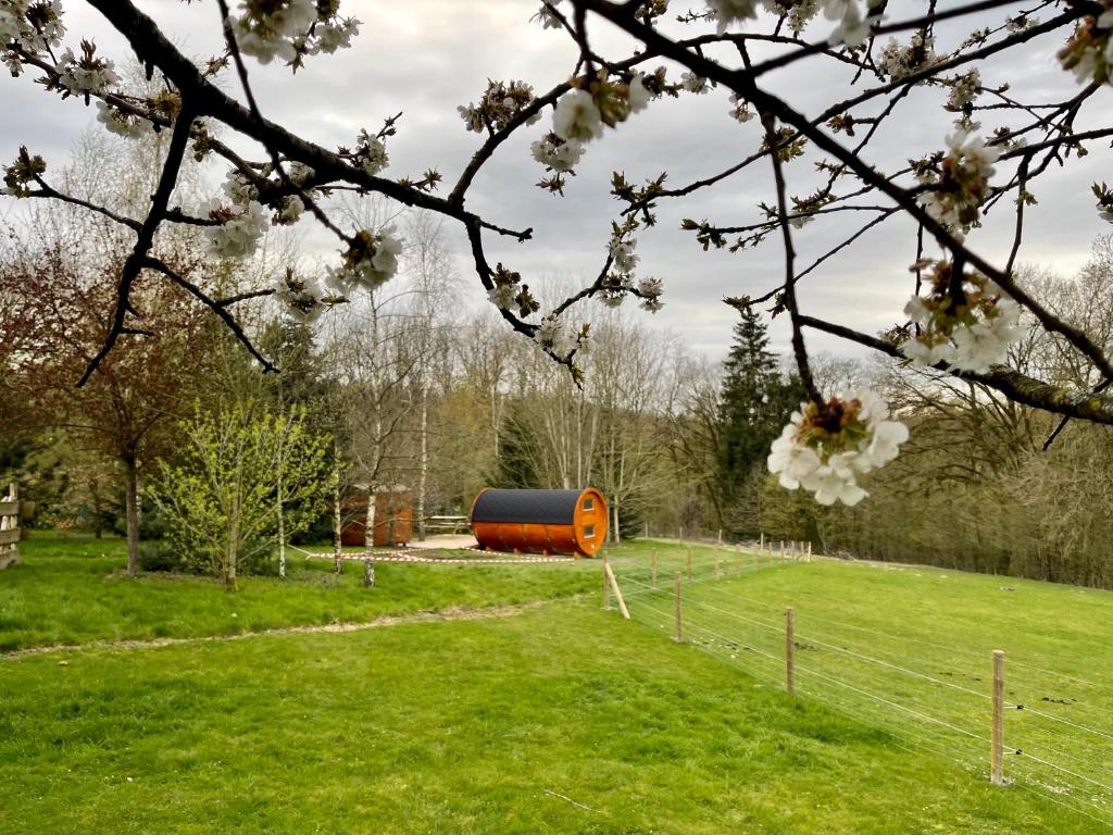 a barn in a field with an orange structure at Le Hameau in Florent-en-Argonne