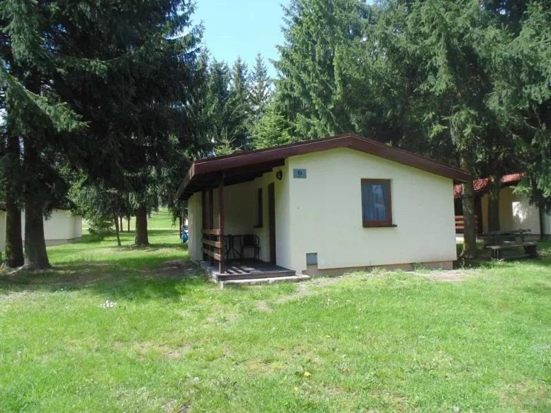 una pequeña casa en un campo con árboles en Dolina Bugu Kodeń, en Kodeń