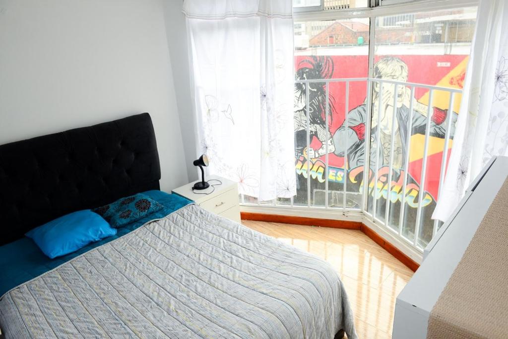 a bedroom with a bed in front of a window at Acogedor Apartamento La Candelaria 2 Habitaciones EC52 in Bogotá