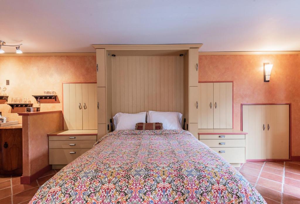 a bedroom with a large bed and a kitchen at Salt Spring Carriage House B&B in Ganges