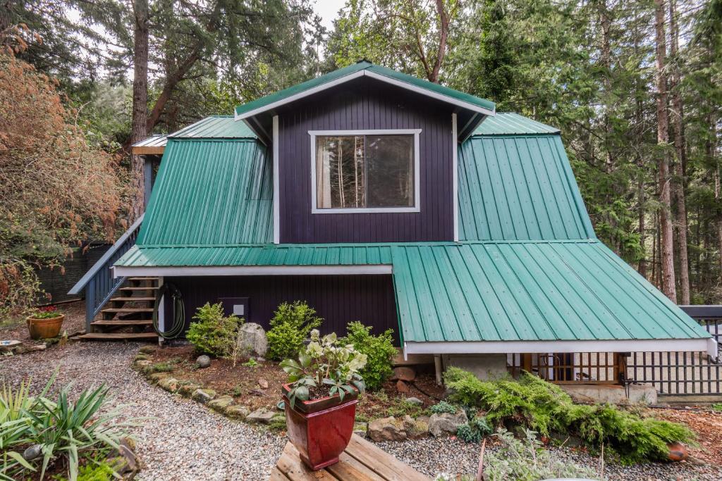 a house with a green roof at Salt Spring Carriage House B&B in Ganges