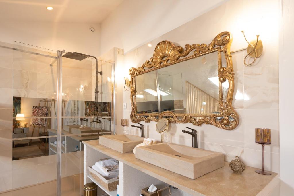 a bathroom with a sink and a mirror on the wall at L'Avant Scène Meublé 5 étoiles Parking Gratuit Jacuzzi in Avignon