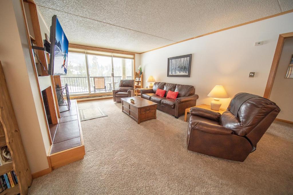 a living room with two couches and a television at Pines 2086 in Keystone
