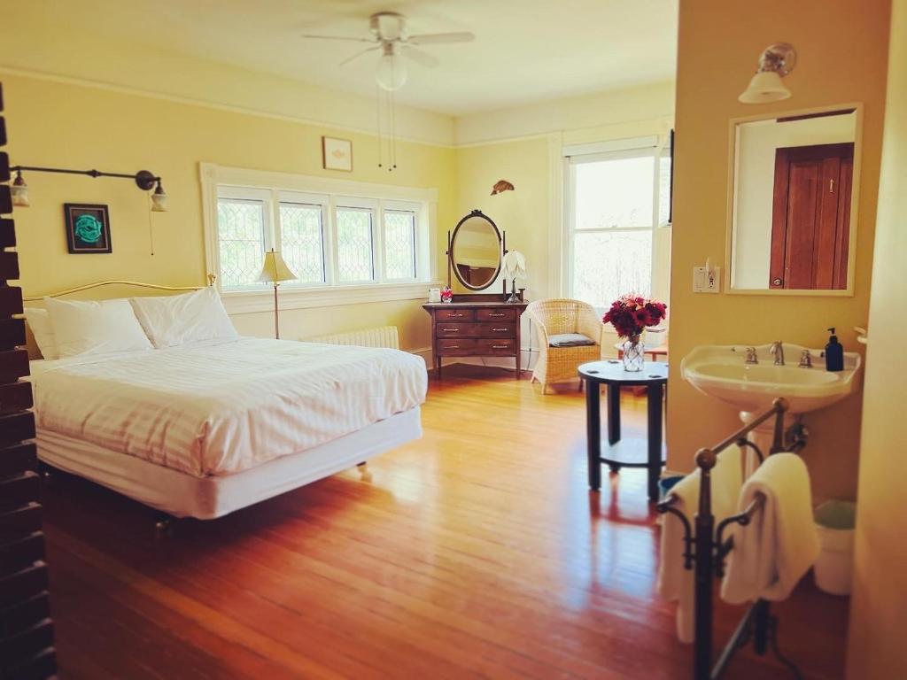 Schlafzimmer mit einem Bett, einem Waschbecken und einem Spiegel in der Unterkunft Sasquatch Crossing Eco Lodge B&B in Harrison Mills