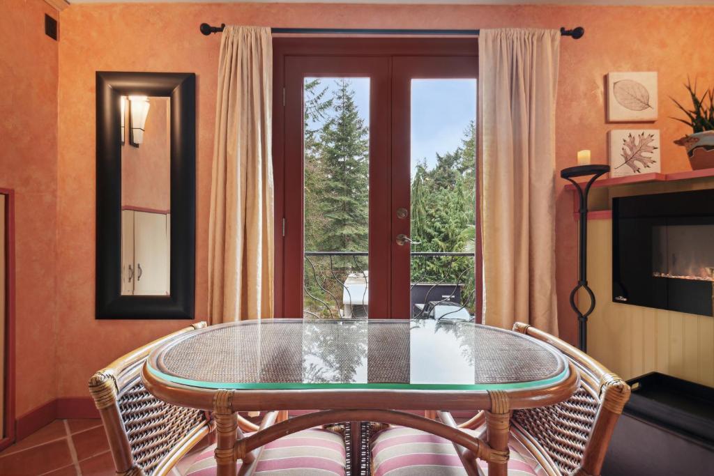 a dining room with a glass table and a window at Salt Spring Carriage House B&B in Ganges