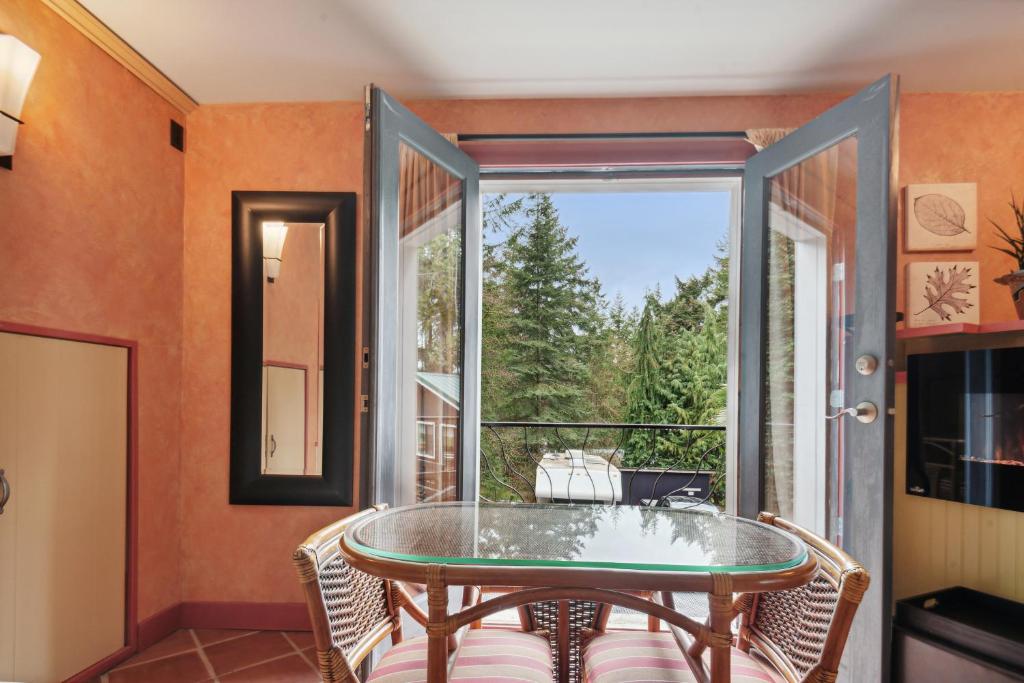 a room with a glass table and a large window at Salt Spring Carriage House B&B in Ganges