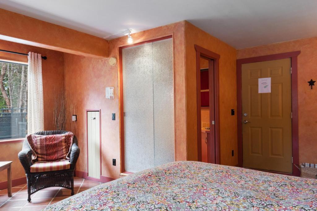 a bedroom with a bed and a chair and a window at Salt Spring Carriage House B&B in Ganges