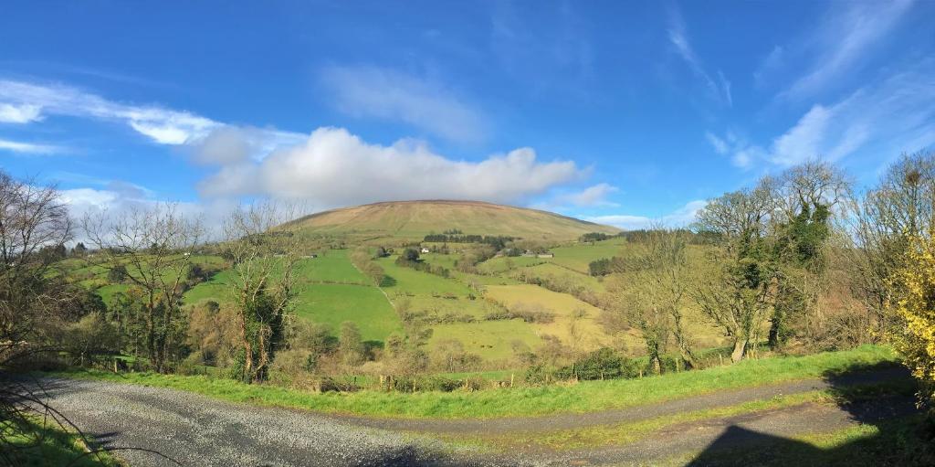 uma colina relvada no meio de uma estrada em Ballycastle Glenview House 4 bedrooms in the Glens of Antrim em Ballycastle