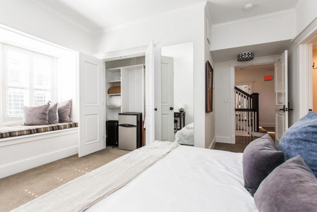 biała sypialnia z dużym łóżkiem i oknem w obiekcie Valentine at Oak Street Mansion w mieście Kansas City