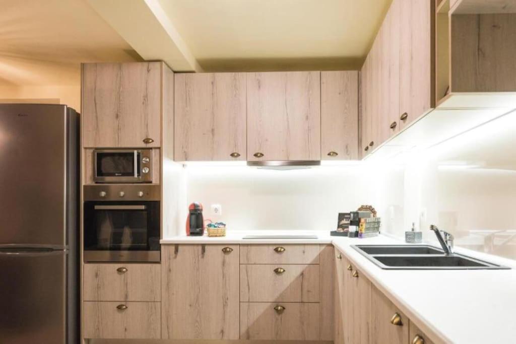 a kitchen with wooden cabinets and a stainless steel refrigerator at Casa Di Valentina in Rhodes Town