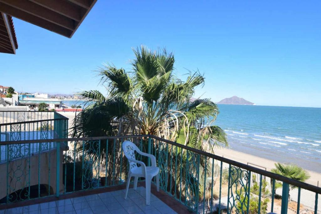 - une chaise blanche assise sur un balcon donnant sur la plage dans l'établissement Huge luxury on the beach, à San Felipe