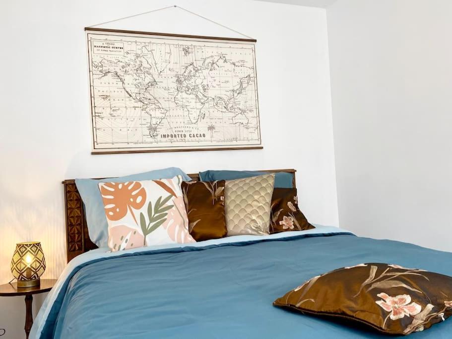 Un dormitorio con una cama azul con un mapa en la pared en Le Familik- Maison- CentreVille, en Licques