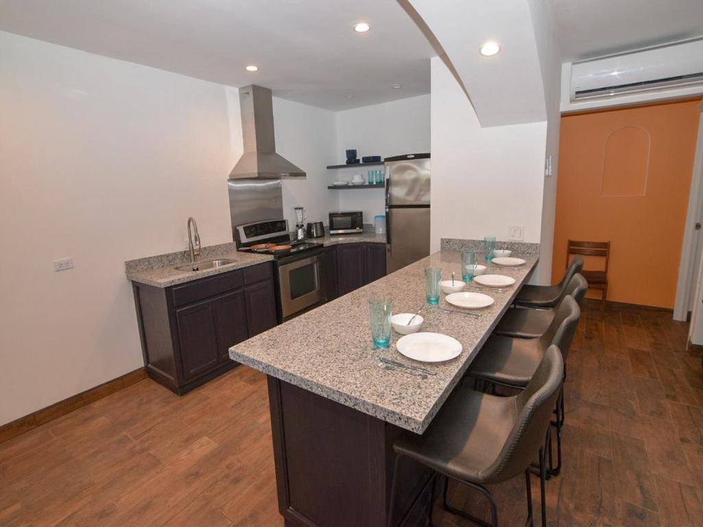 a kitchen with a long island with a bar with chairs at La Hacienda San Felipe Rental Condo 2 in San Felipe