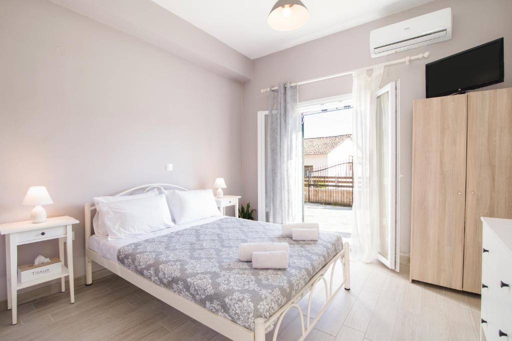 a white bedroom with a bed and a tv at Elizabeth's paradise in Kanálion