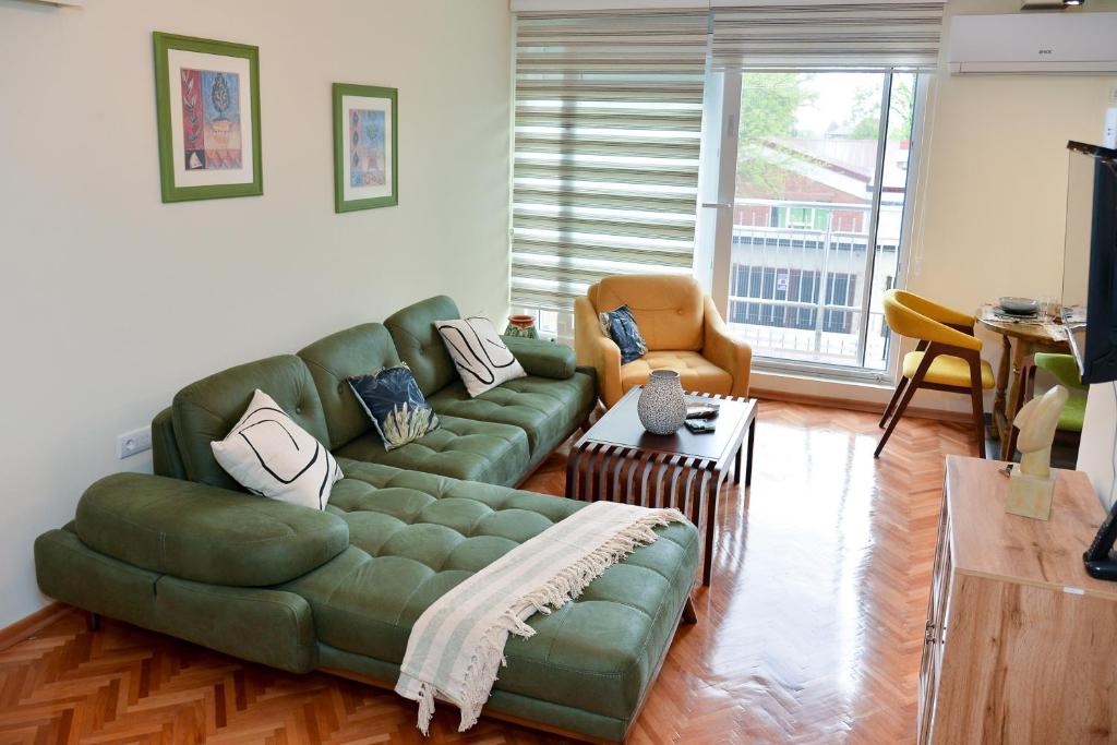 a living room with a green couch and a table at Apartman Lenka in Arandjelovac