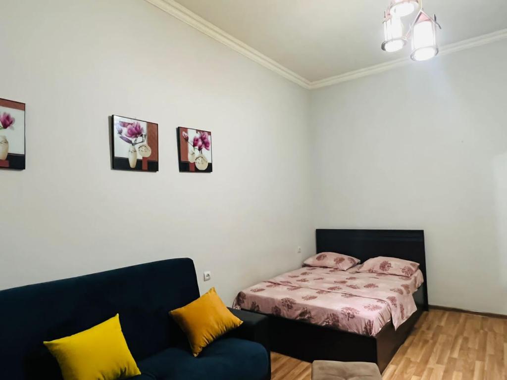 a bedroom with a bed and a couch at Apartment on Bagratuniats Street in Yerevan
