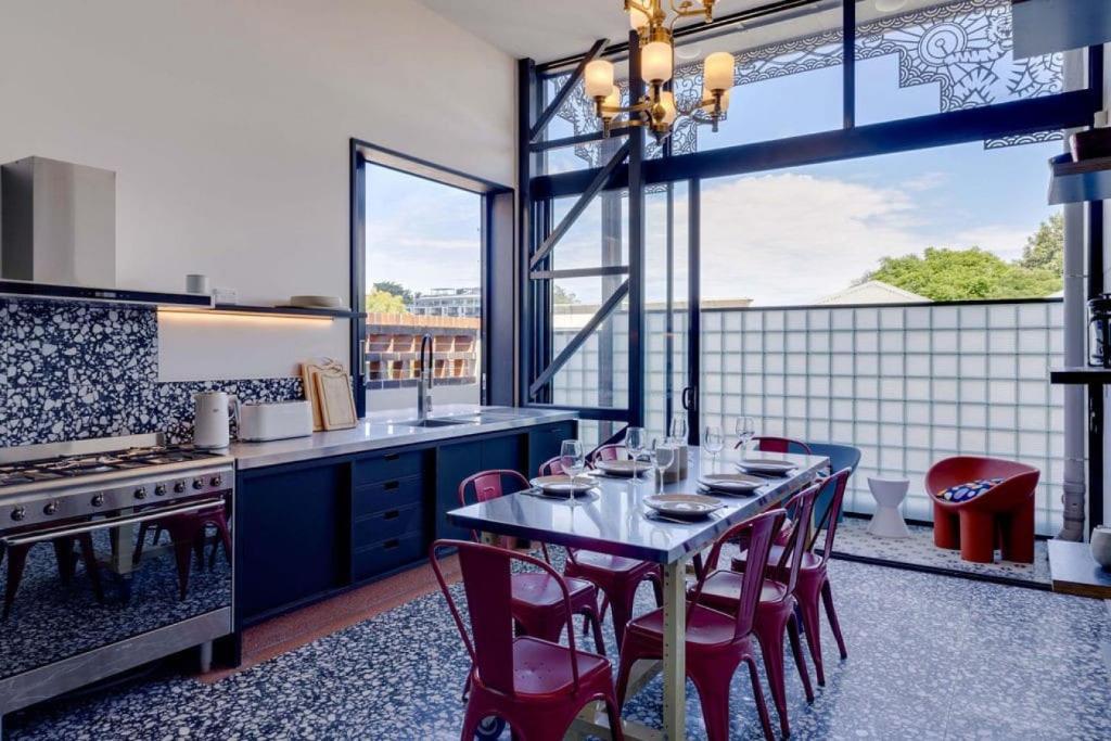 uma cozinha com uma mesa e algumas cadeiras vermelhas em Escape 2 the City NEW apartment 3bed Highgate Hill em Brisbane