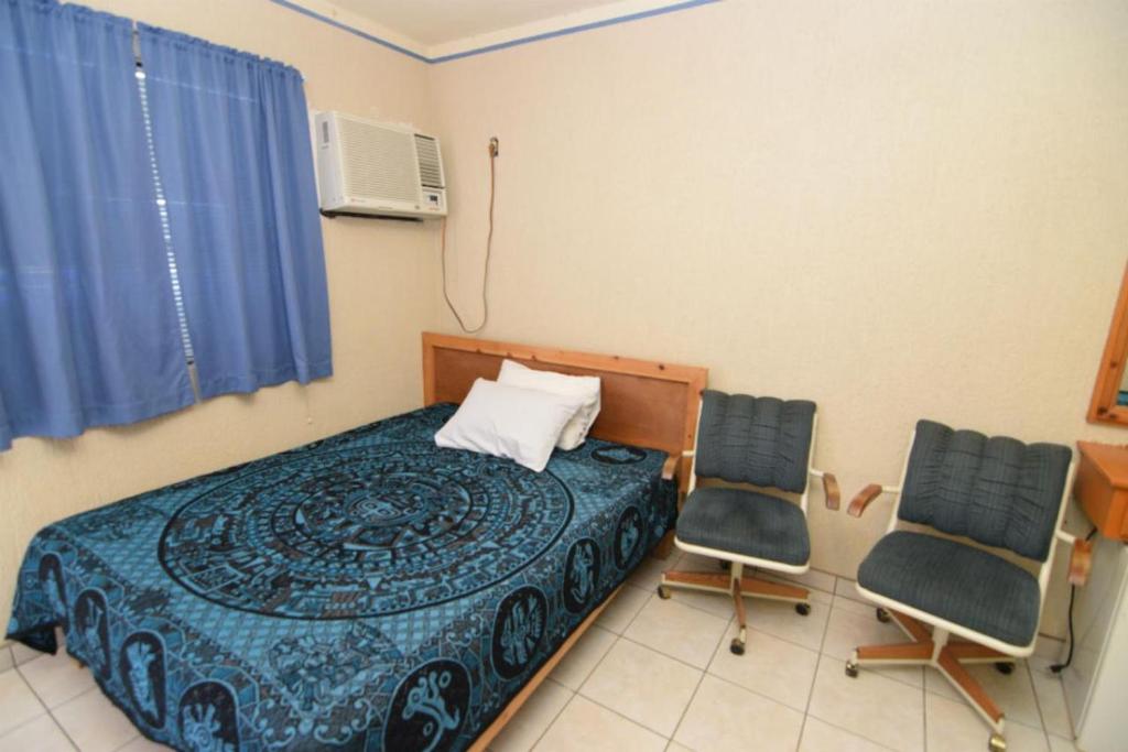 una camera da letto con un letto e due sedie di San Felipe Rental Studio 3 Free WiFi and Cable TV a San Felipe