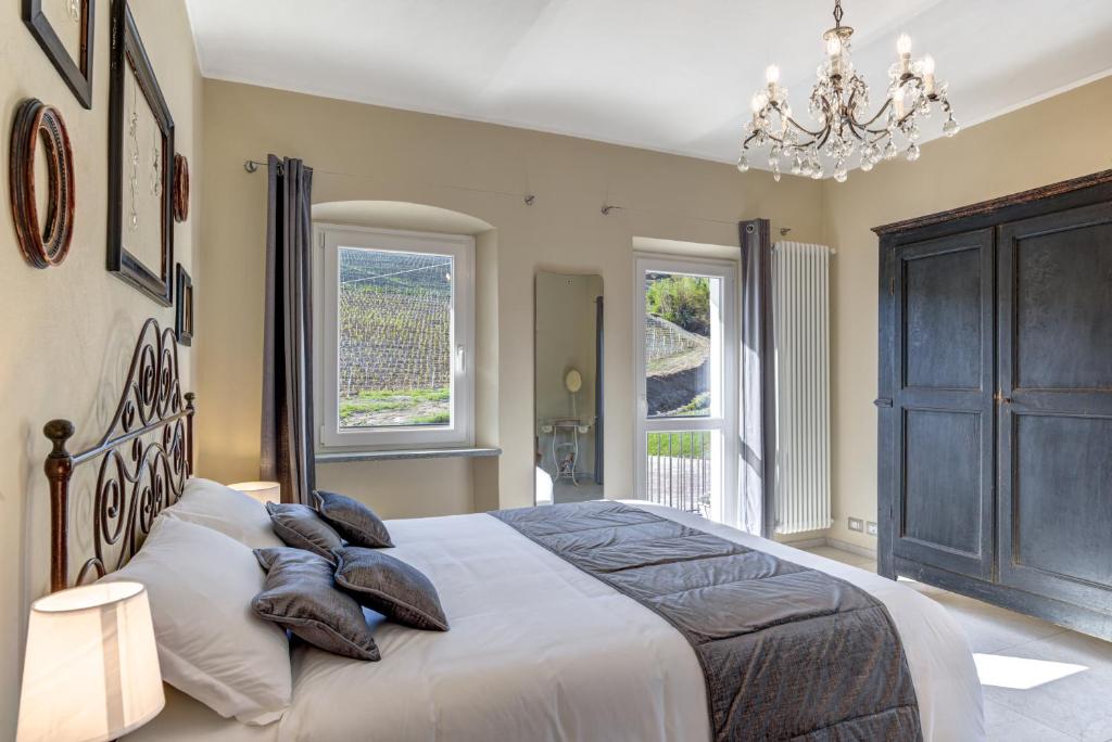 a bedroom with a large bed with pillows and a chandelier at Ciabot delle Aie - Barolo in Barolo