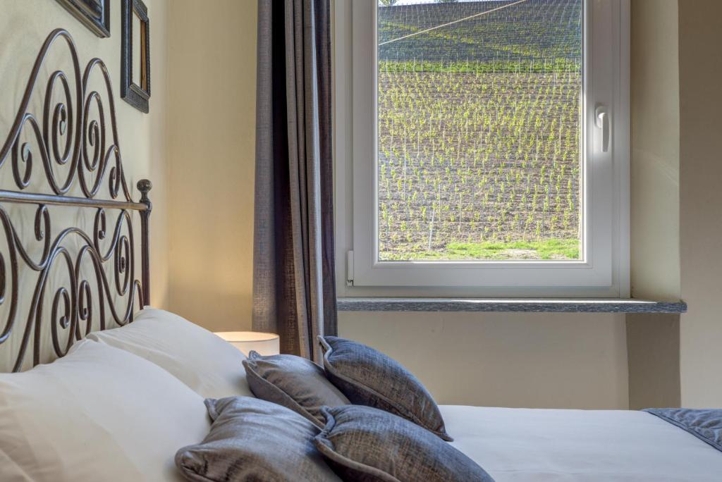 a bed with pillows and a window in a room at Ciabot delle Aie - Barolo in Barolo