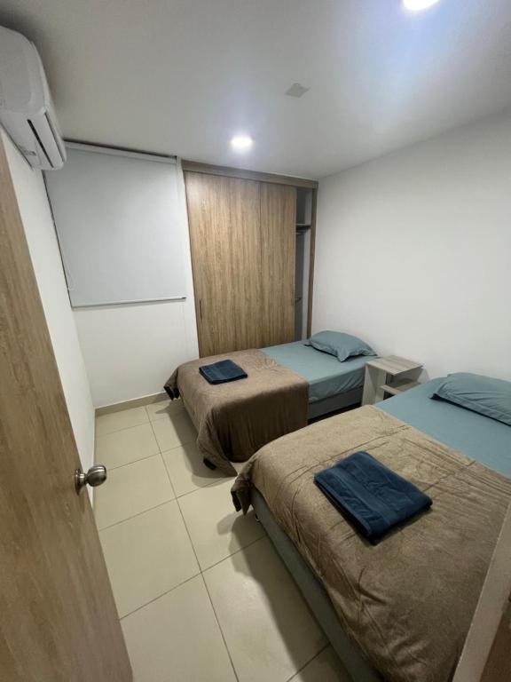 Habitación con 2 camas y puerta a una habitación en Bello Horizonte Plaza - Apartamento, en Santa Marta