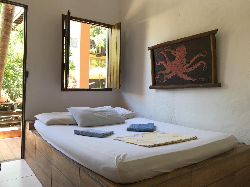 a bed with two pillows on it in a room at Toca da Rapoza in Salvador