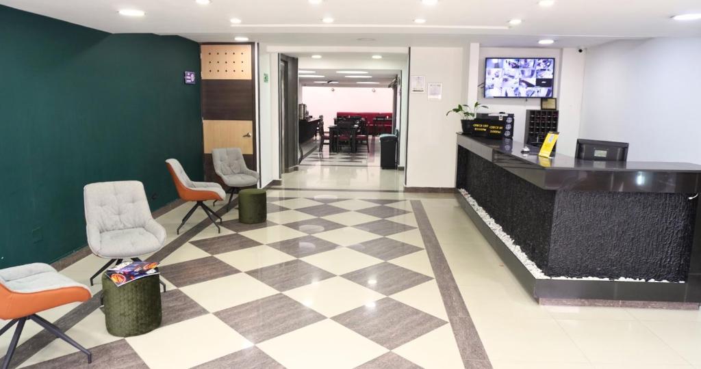 a lobby with chairs and a checkerboard floor at Hotel Expo Hotel Ferial in Bogotá