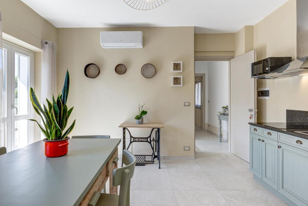 a kitchen with white cabinets and a table with a potted plant at Ciabot delle Aie - Barolo in Barolo