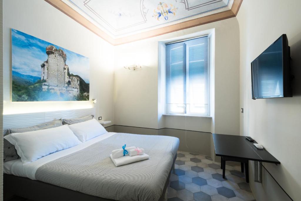 1 dormitorio con cama, escritorio y ventana en FINARIN Guest House, en Finale Ligure