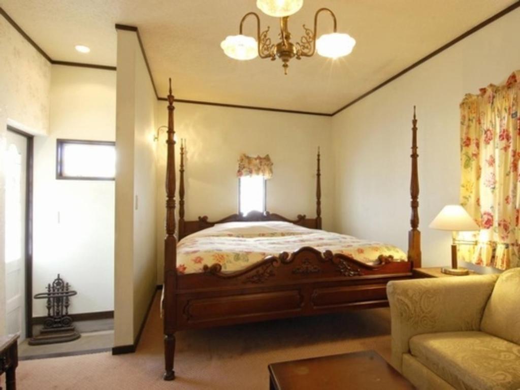 1 dormitorio con 1 cama y 1 sofá en Gasthof Ami - Vacation STAY 96492v en Nikko