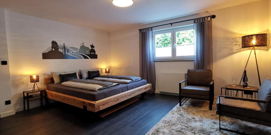 1 dormitorio con 1 cama, 1 silla y 1 ventana en Mosel19 - Moderne, hochwertige Ferienwohnung en Niederfell