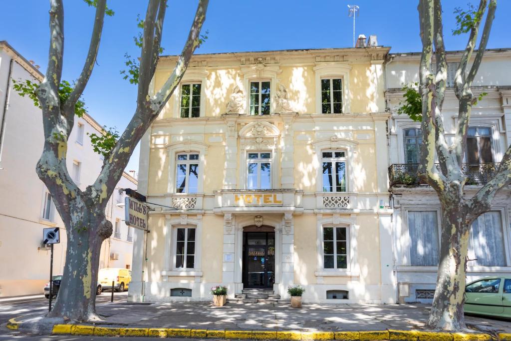 a white building with trees in front of it at Will's Hotel in Narbonne