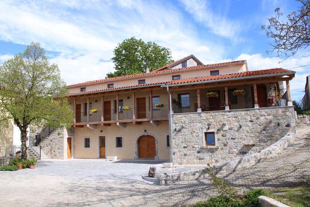 Dutovlje的住宿－G House，一座大型石头建筑,上面设有阳台