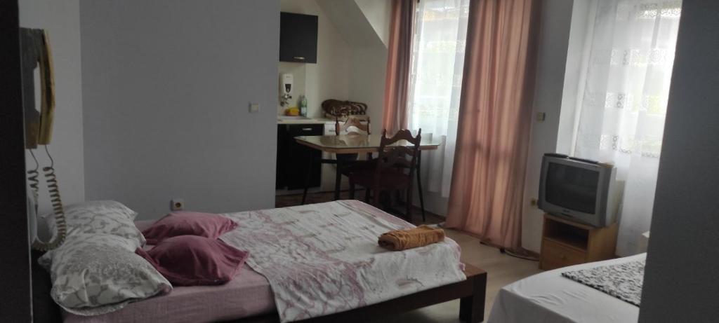 a small bedroom with a bed and a tv at Apartment Ivaylo in Varna City