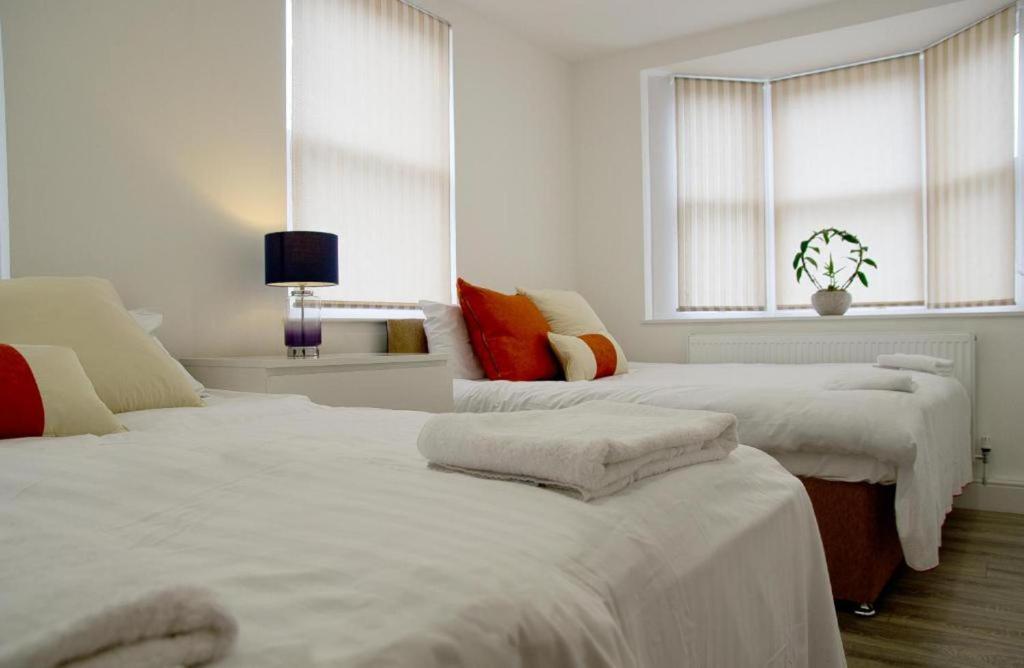 Habitación blanca con 2 camas y 2 ventanas en Stunning 2-Bed Apartment in Chelmsford en Chelmsford