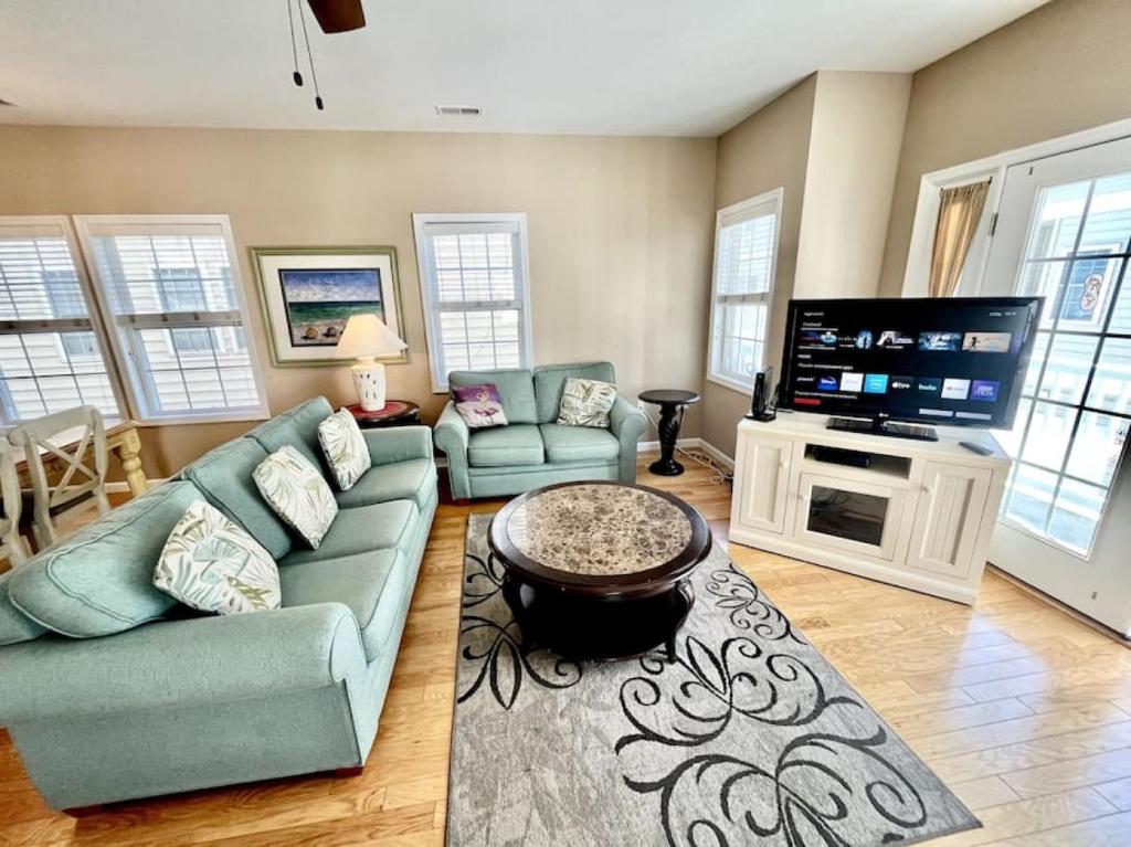 a living room with a couch and a flat screen tv at Beach Block 4 Bedroom with POOL in North Wildwood