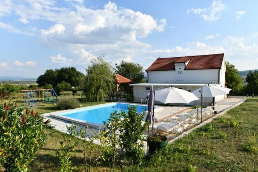 a villa with a swimming pool and a house at Kovacic Villa with pool, tennis cart and free parking in Hrvace