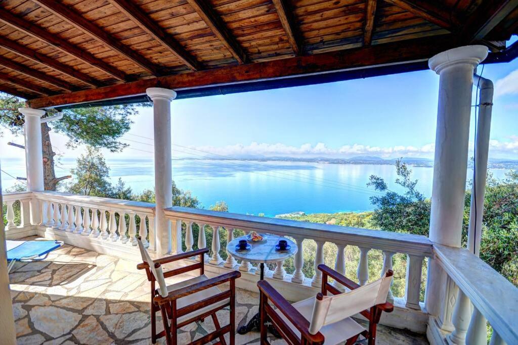 a porch with chairs and a table and a view of the water at Rolling Stolis Home in Katávolos