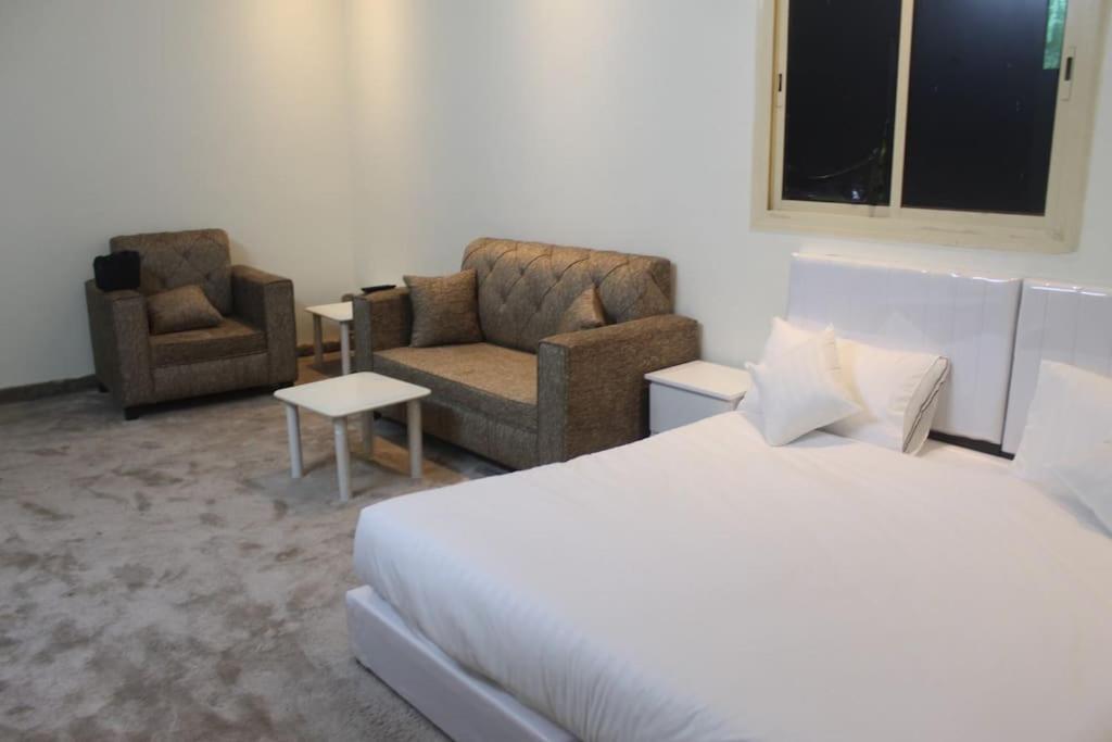 a hotel room with a bed and two chairs at شقة خاصة للعائلات فقط in Al Madinah