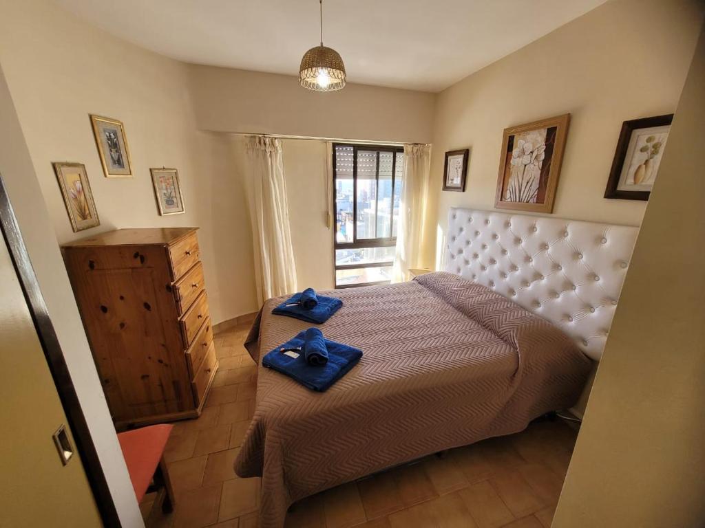 a bedroom with a bed with blue towels on it at Panoramico in Santa Teresita