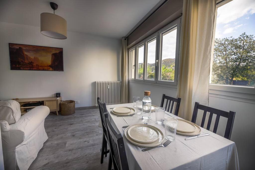 une salle à manger avec une table, une nappe blanche et des chaises dans l'établissement • Au Cosy Dôme. •, à Royat