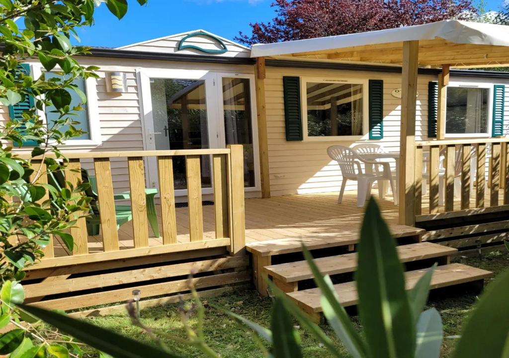 une maison avec une terrasse en bois et une table dans l'établissement Chez Coralie, à La Roque-dʼAnthéron