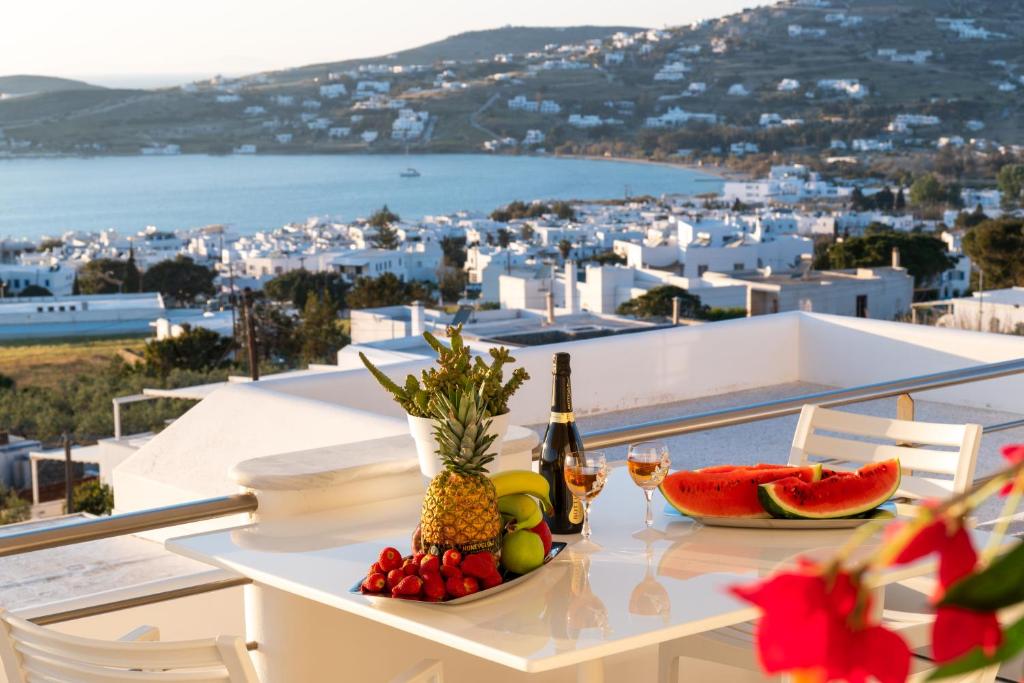 einen Tisch mit einer Flasche Wein und Obst auf dem Balkon in der Unterkunft Panos Luxury Suite in Parikia