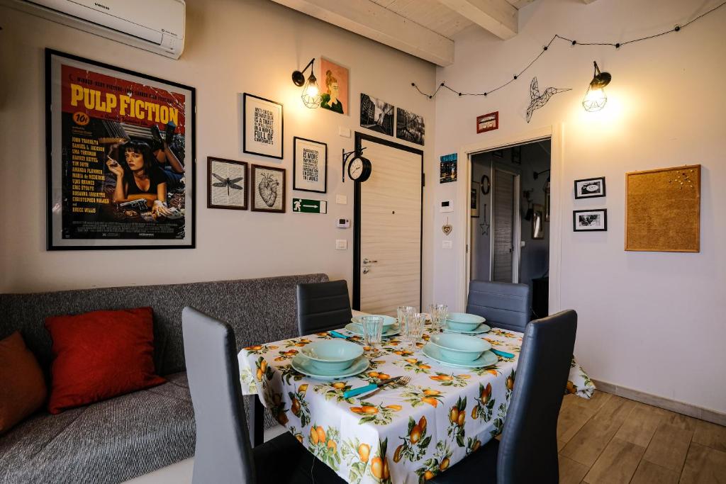 ein Esszimmer mit einem Tisch mit Stühlen und Tischdecken in der Unterkunft La Mansarda Vintage in Moncalieri