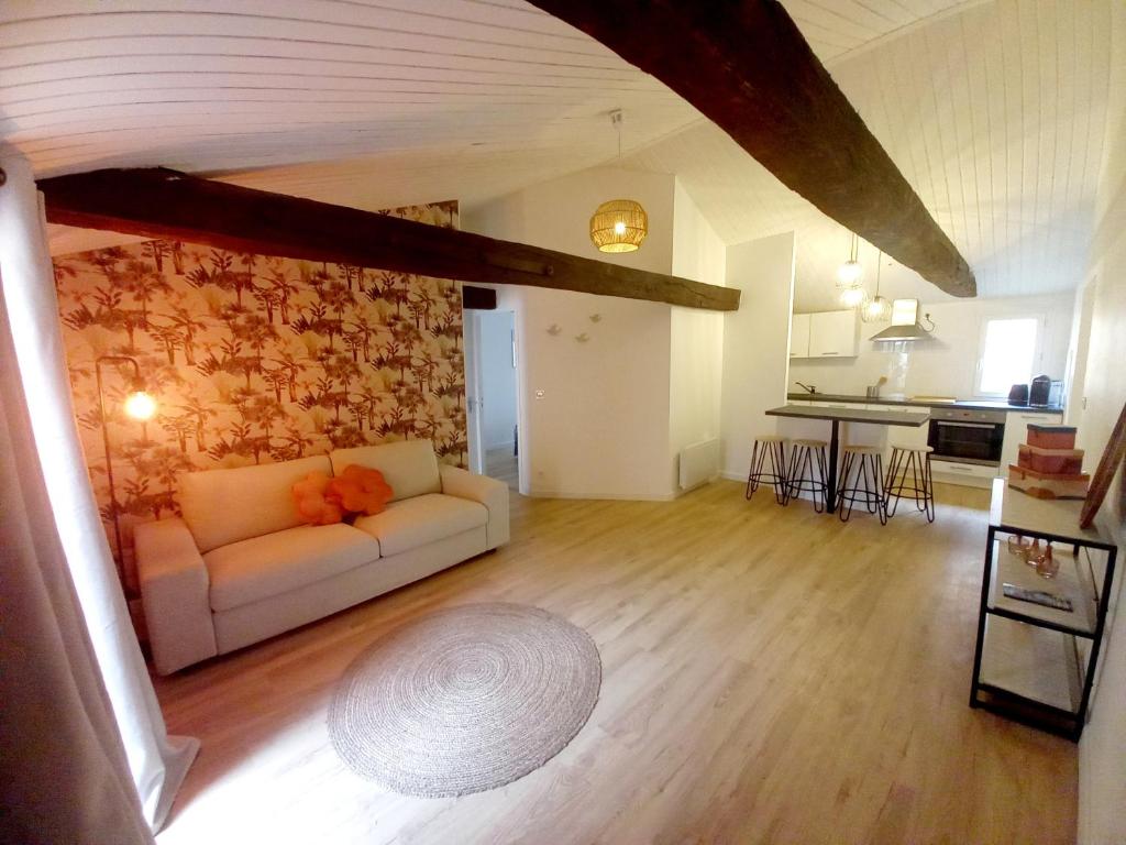 - un salon avec un canapé blanc et un mur en pierre dans l'établissement Bienvenue à Figeac, à Figeac